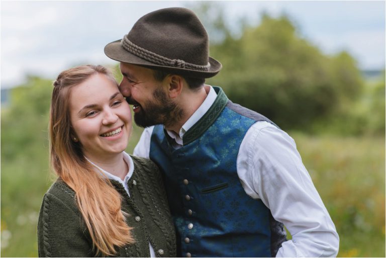 Mann flüstert seiner Freundin etwas ins Ohr
