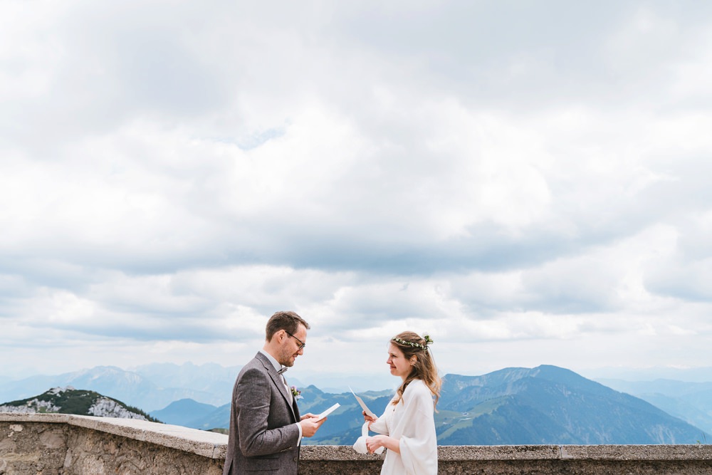 Brautpaar hält sich vor Bergkulisse ihr Eheversprechen