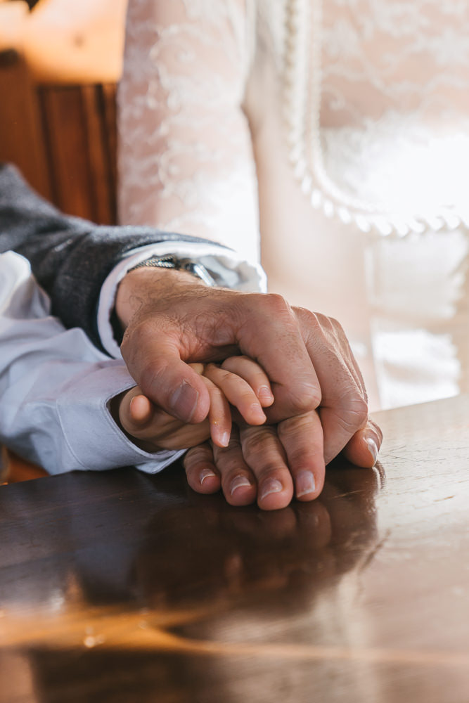 Eltern halten Kinderhand bei Trauung